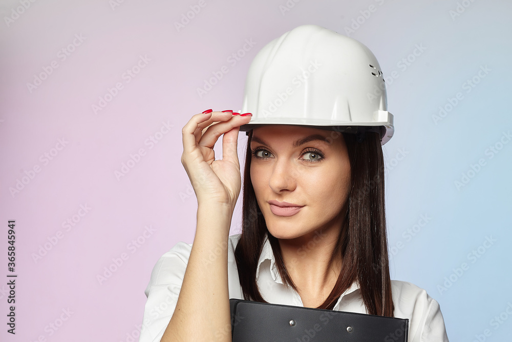 the girl in the white helmet points the direction with her hand. the concept of a businesswoman who understands construction, repair and modernization.. the girl in the white helmet points the direction with her hand. the concept of a businesswoman who understands construction, repair and modernization..