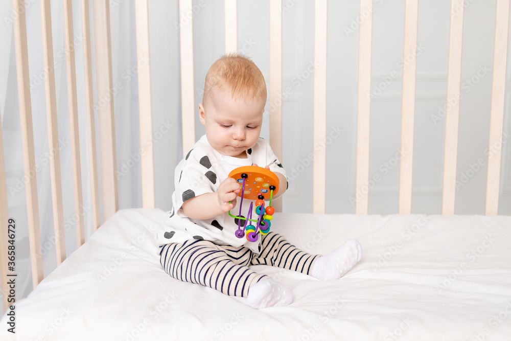 baby 8 months playing in the crib, early development of children up to a year, a place for text baby 8 months playing in the crib, early development of children up to a year, a place for text