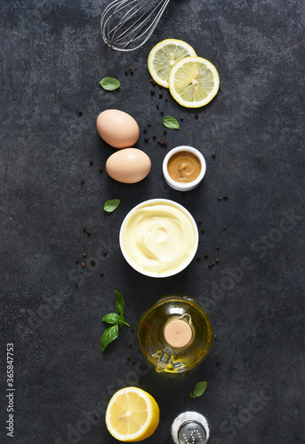 Homemade mayonnaise on a black background. Ingredients for making the sauce: egg, butter, mustard.