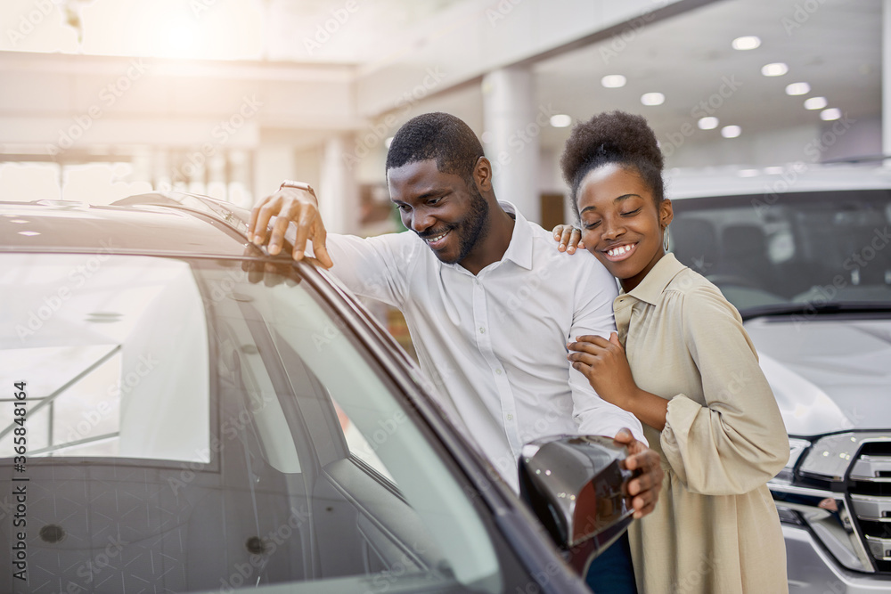 portrait of beautiful african married couple came in dealership to buy their first family car. happy customers make purchase, choose - obrazy, fototapety, plakaty 