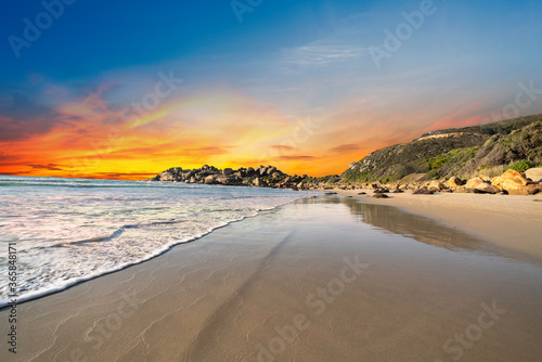 Llandudno sandy Beach at sunset with rocks and mountain in Cape Town South Africa
