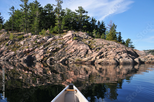 Canoe and rocky shoreline of George Lake and La Cloche mountains Killarney Park Ontario Canada