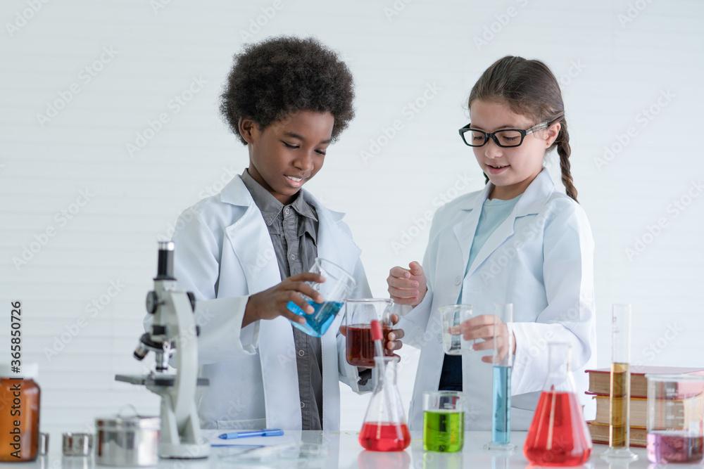 Two children scientists making experiments chemical in the laboratory room at school.Science and education concept. Two children scientists making experiments chemical in the laboratory room at school.Science and education concept.