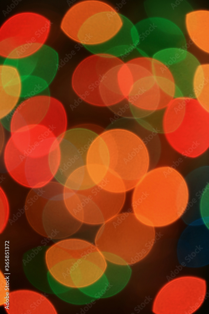Vertical Image of Abstract Blurred Multi-color Glittering Illuminated Light on Black Background	