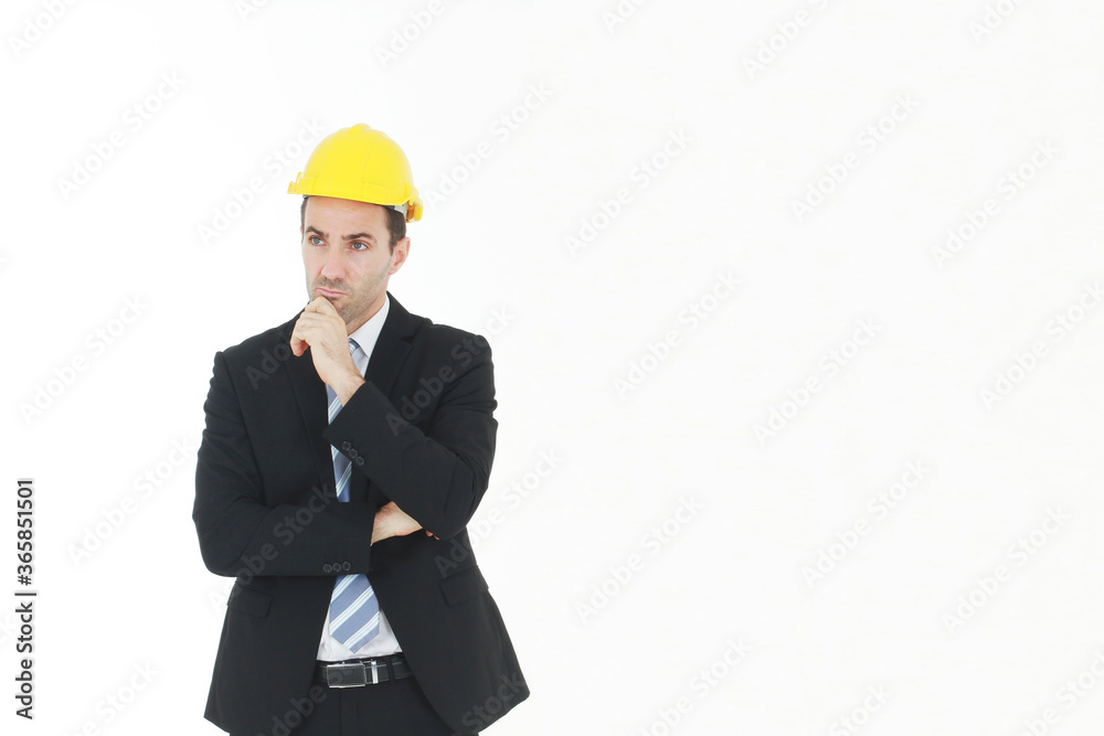 Handsome and smart engineer in black suit Wearing a yellow safety engineering hat Thinking and serious in work isolated on yellow background. Copy Space Handsome and smart engineer in black suit Wearing a yellow safety engineering hat Thinking and serious in work isolated on yellow background. Copy Space