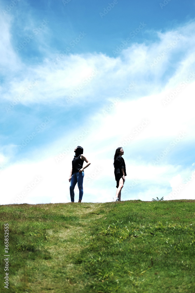 Silhouette Asian sexy women couple standing on Mountain green meadow for freedom and happy on the blue sky. Happiness of life is successful and travel in the world. Silhouette Asian sexy women couple standing on Mountain green meadow for freedom and happy on the blue sky. Happiness of life is successful and travel in the world.
