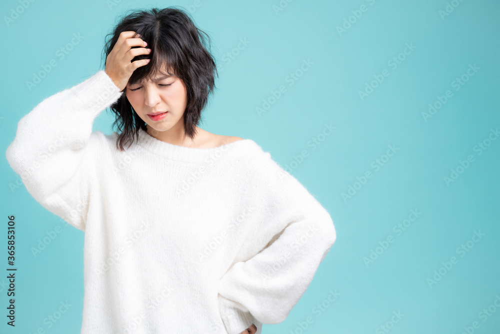 Nervous young Asian girl image isolated on blue studio background. Nervous young Asian girl image isolated on blue studio background.