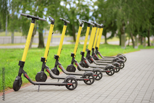 Yellow motorized scooters arranged in a row.