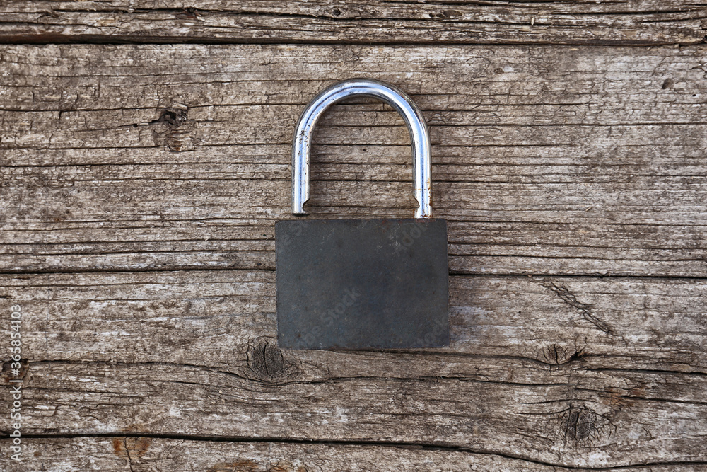 Fototapeta premium the old padlock lies on the wooden surface