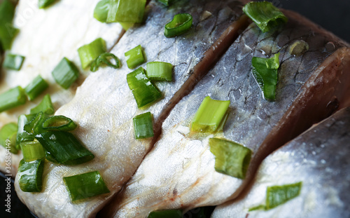 Salted herring with spice and onion on plate. Close up