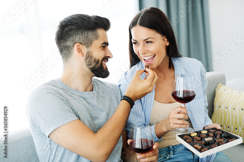 Billede på lærred woman couple man happy happiness  love young chocolate praline eating together r