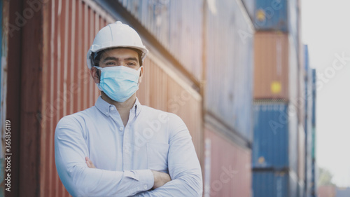 Portrait of a construction worker wearing a hard hat and mask Standing in the workplace Such as container, factory, warehouse For safety during work. Concept Prevent Coronavirus