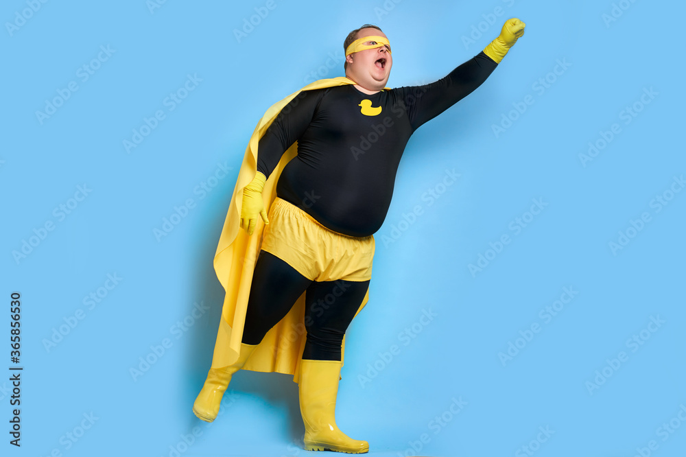 portrait of enthusiastic cleaning superhero isolated over blue background. yellow duck is a symbol of bathing and cleaning. man is ready to clean portrait of enthusiastic cleaning superhero isolated over blue background. yellow duck is a symbol of bathing and cleaning. man is ready to clean