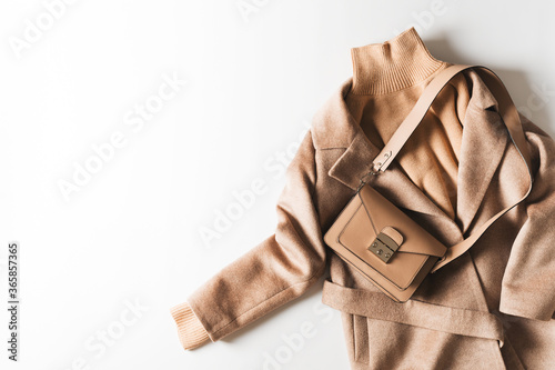 Fashion flat lay with beige caramel casual sweater, coat and boots with panpas grass on white background photo