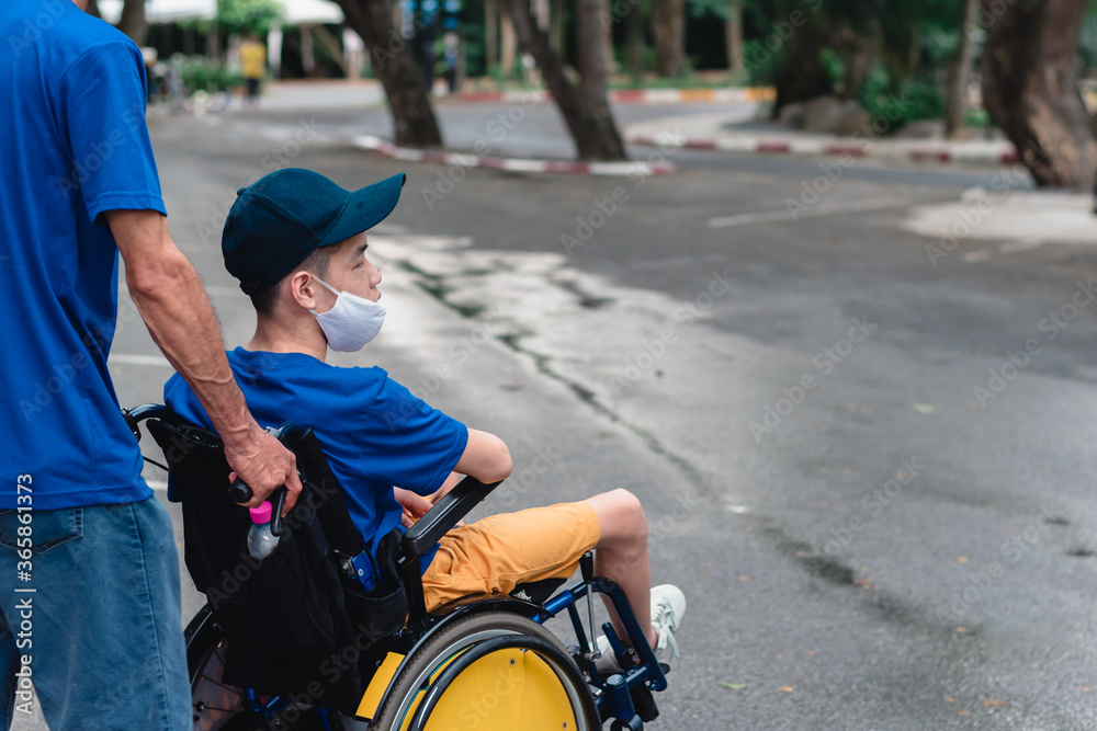 Obraz premium Asian special child on wheelchair wearing mask protection flu Covid 19 or Coronavirus,Wear N95 or cotton masks when to do outdoor activities,New normal to prevent the spread of the virus disease 2020.