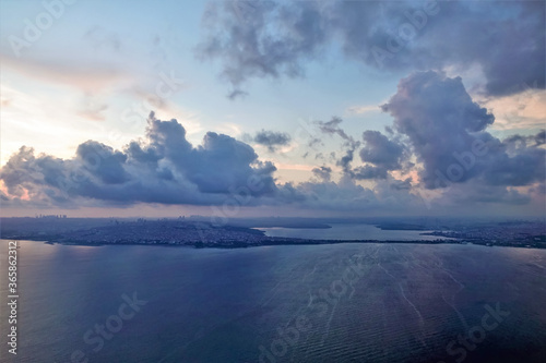 Fototapeta Naklejka Na Ścianę i Meble -  Istanbul and the Bosphorus at sunrise from a height. The deep blue surface of the water is calm.The city is visible in the distance. In the brightening sky there are picturesque pink and purple clouds