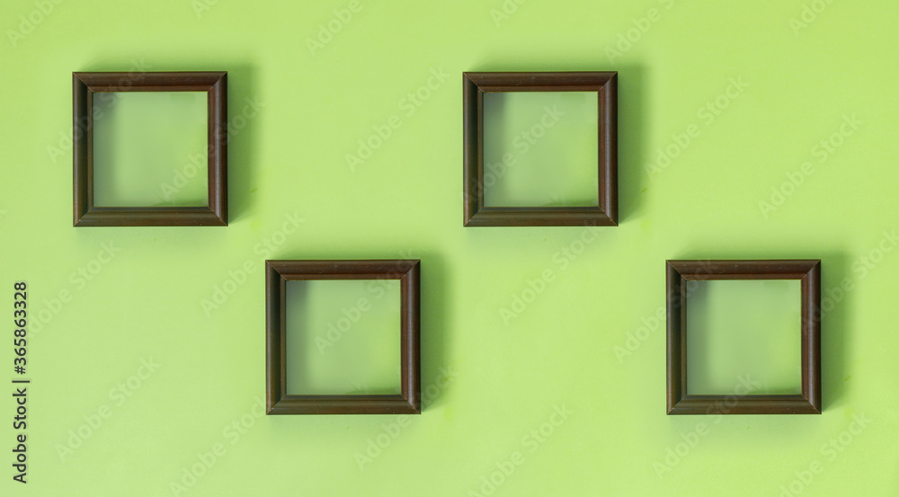 Wooden brown frame on green wall in retro style. Interior concept. Modern home decor. Wooden brown frame on green wall in retro style. Interior concept. Modern home decor.