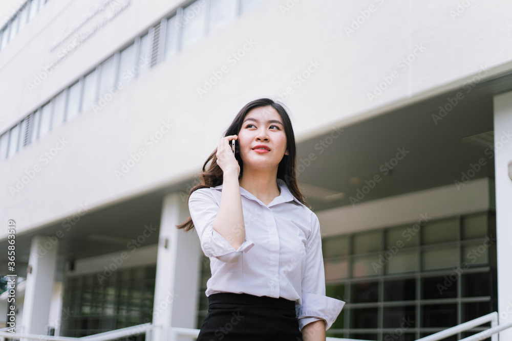 Beautiful asian business woman talking on cellphone while walking outdoor Beautiful asian business woman talking on cellphone while walking outdoor