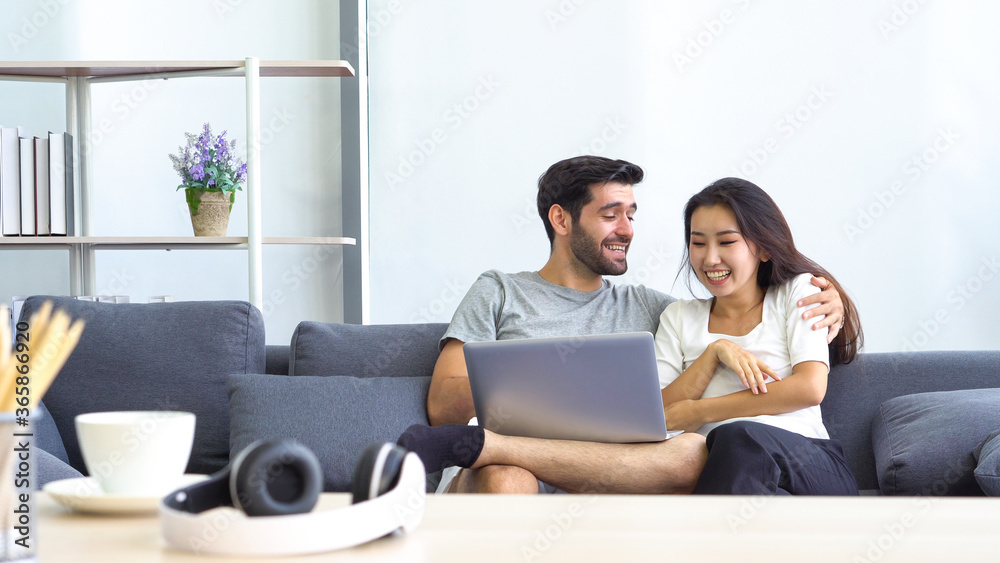 young asian woman and caucasian man using computer to work from home. couple together and relationship young asian woman and caucasian man using computer to work from home. couple together and relationship