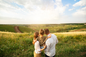 Happy family enjoying landscape outdoors in the field