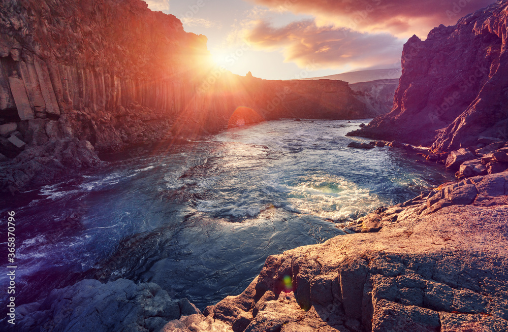 Amazing view of landscape under sunlit, during sunset in Iceland. Powerful river in canyon with black basalt columns under sunlight, Tipical Icelandic scenery. Amazing nature scene.