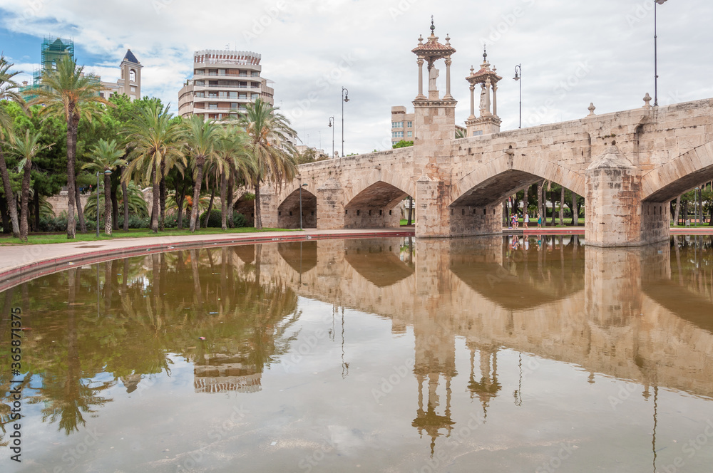 Medieval stone bridge over the Turia river promenade in the city of Valencia