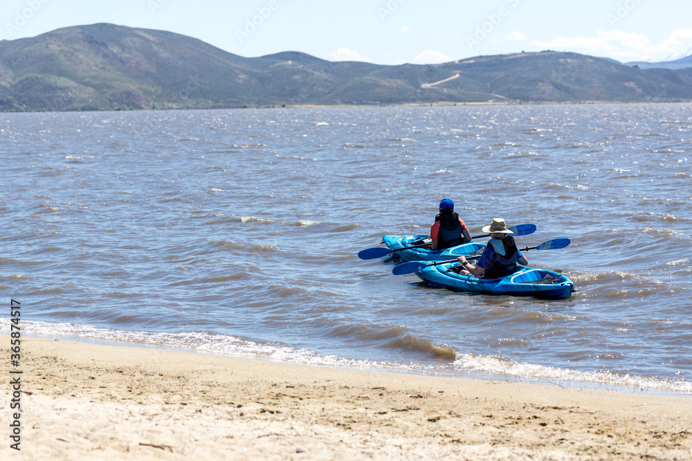 Two kayakers  paddling on a windy day close to the beach at Washoe Lake