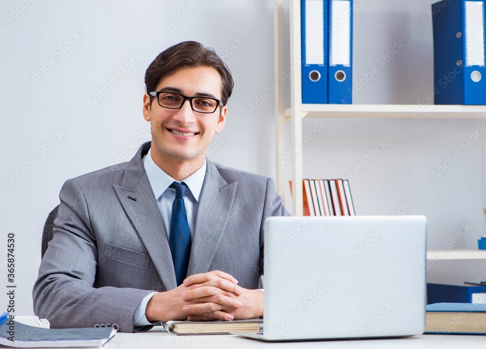 Young handsome businessman employee working in office at desk Young handsome businessman employee working in office at desk
