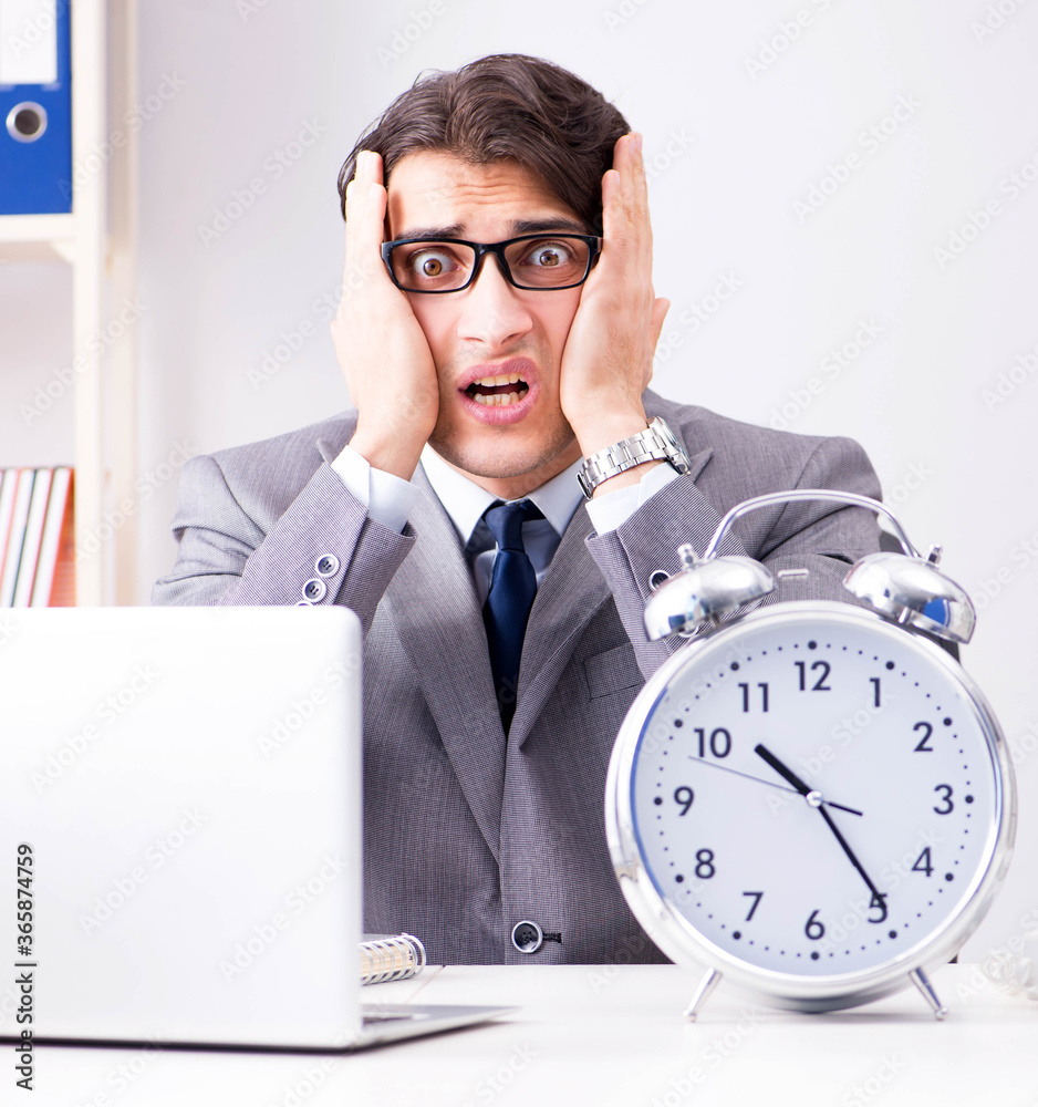 Businessman employee in urgency and deadline concept with alarm Businessman employee in urgency and deadline concept with alarm