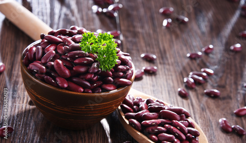 Composition with bowl of kidney bean on wooden table photo