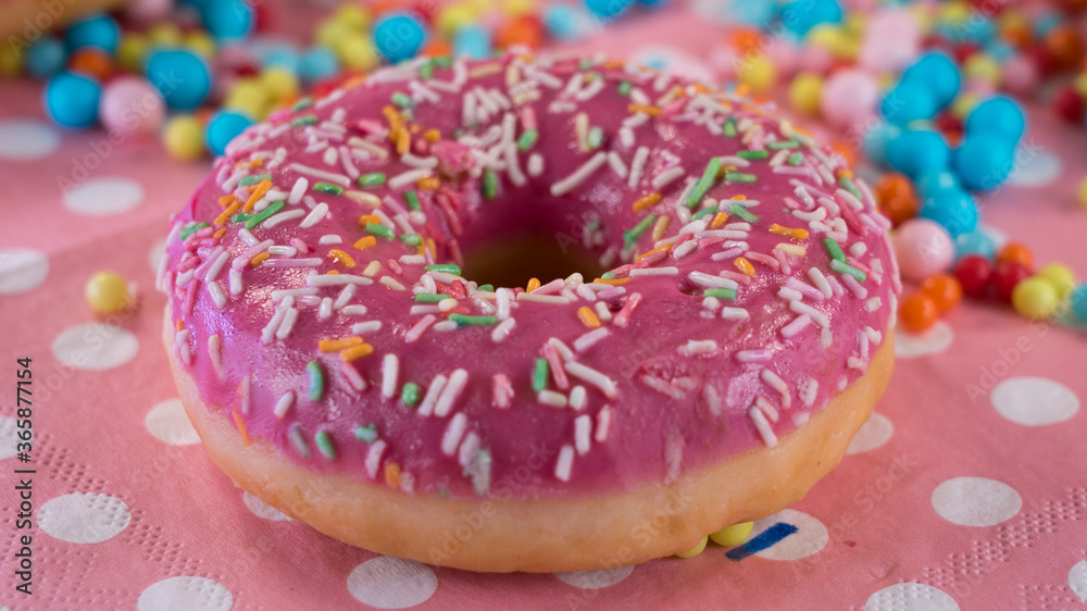 Tasty looking pink donut with colorful sprinkle. Beautiful pink wallpaper with sweet and delicious doughnut. Tasty looking pink donut with colorful sprinkle. Beautiful pink wallpaper with sweet and delicious doughnut.
