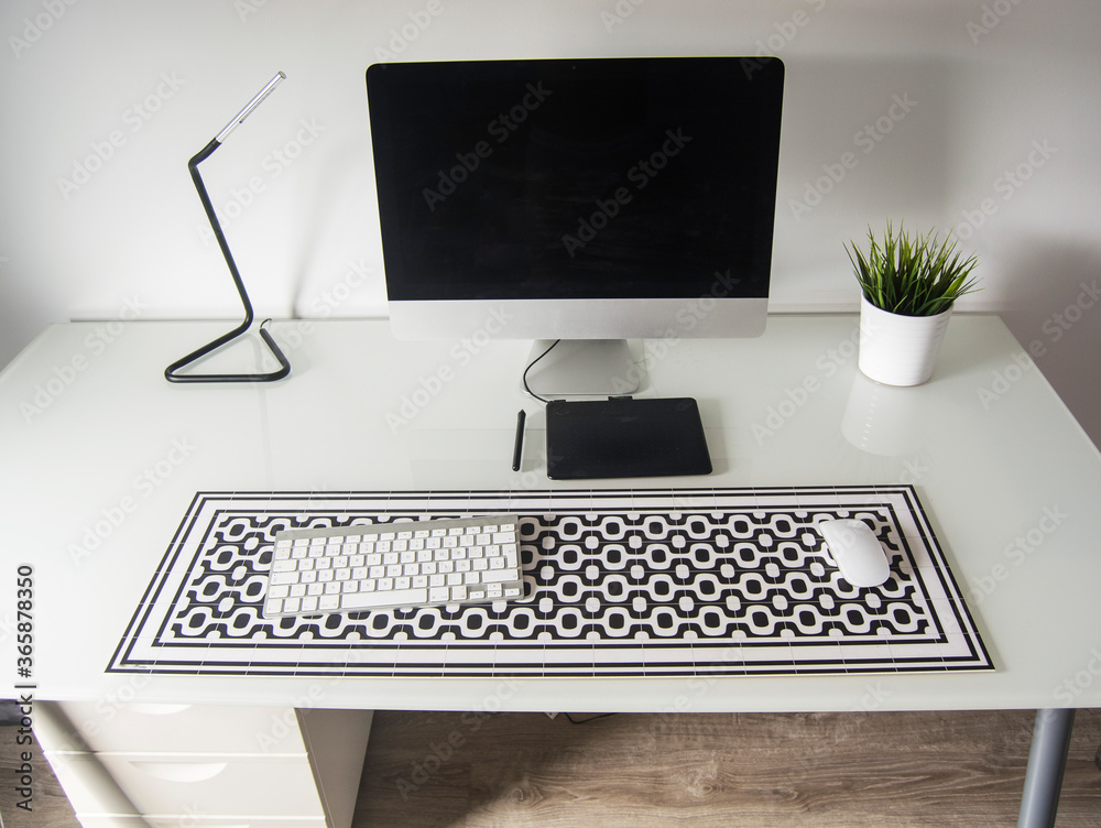 escritorio de cristal con ordenador y tableta gráfica encima de alfombra de mesa, trabajo desde casa escritorio de cristal con ordenador y tableta gráfica encima de alfombra de mesa, trabajo desde casa