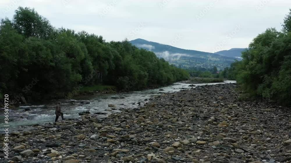 Water stream in a mountain river, fog over tall pines in the Carpathian mountains Water stream in a mountain river, fog over tall pines in the Carpathian mountains