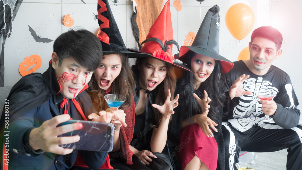 Fototapeta premium Group of 5 friends taking selfie at Halloween costume party. Halloween Holidays and technology concept.