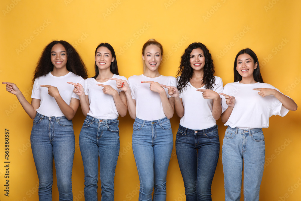 Five Multiracial Women Pointing Fingers Aside Advertising Something, Studio Shot Five Multiracial Women Pointing Fingers Aside Advertising Something, Studio Shot