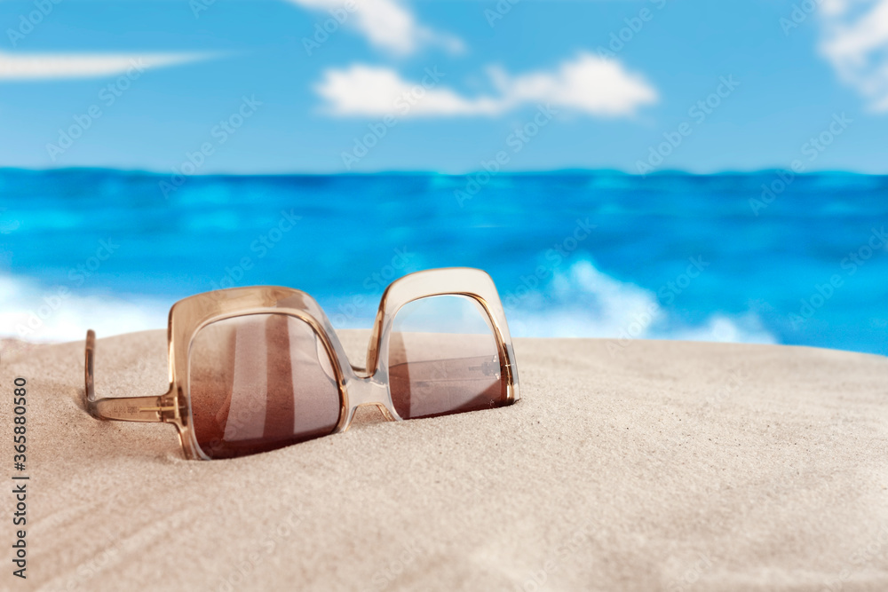 Sunglasses on the seashore, tropical beach vacation background .
