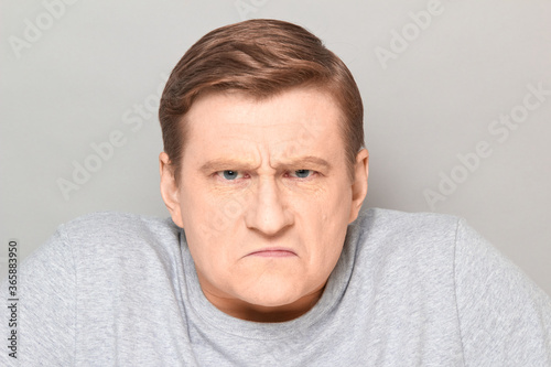 Bild auf Leinwand Portrait of angry disgruntled mature man with frowning face