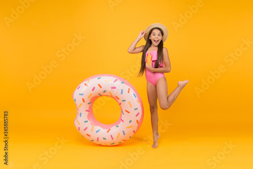 Getting golden tan. little girl going play in water. child and swim ring. summer outdoor activity. kid in swimwear. joyful swimmer relaxing in sea. girl with inflatable rubber ring at swimming pool