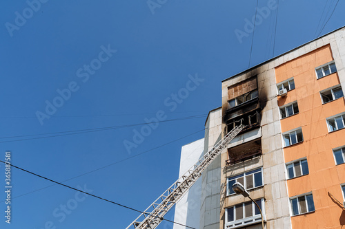 fire on the balcony of a multi-storey building, black clouds of smoke, apartment smoke, extinguishing fire in a residential building, fire escape, emergency, fire, open fire, house fire © Aleksey