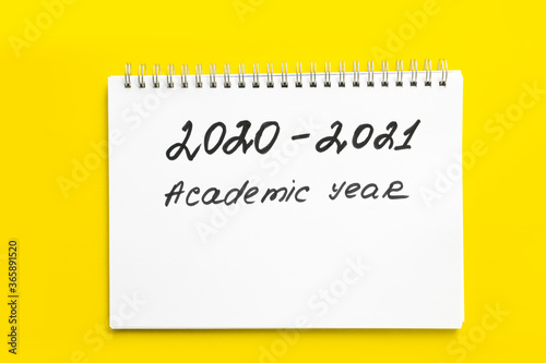 2020 - 2021 academic year. The inscription in a white notebook with a spiral, on a yellow background. Back to school. Concept of the new school year and return to school.