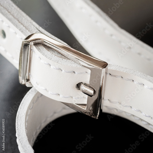 Detail of leather handbag, white strap with silwer metallic buckle photo