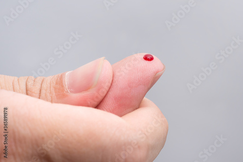 Blood drop on fingertip prepare for checking the glucose level with a glucometer for examining diabetes mellitus.