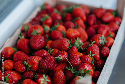 Ripe fresh strawberries close-up in a container for sale. Healthy diet photo
