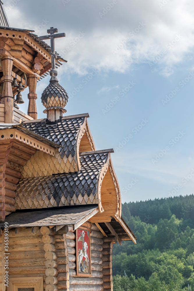 A beautiful wooden Orthodox Christian church against the backdrop of a clear blue sky and green trees. Travel across Russia in the summer. A beautiful wooden Orthodox Christian church against the backdrop of a clear blue sky and green trees. Travel across Russia in the summer.