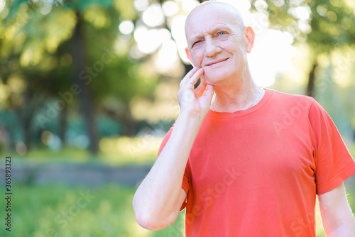 Sad old man suffering from a strong toothache. Elderly person touching their cheek and feel the pain. High quality photo