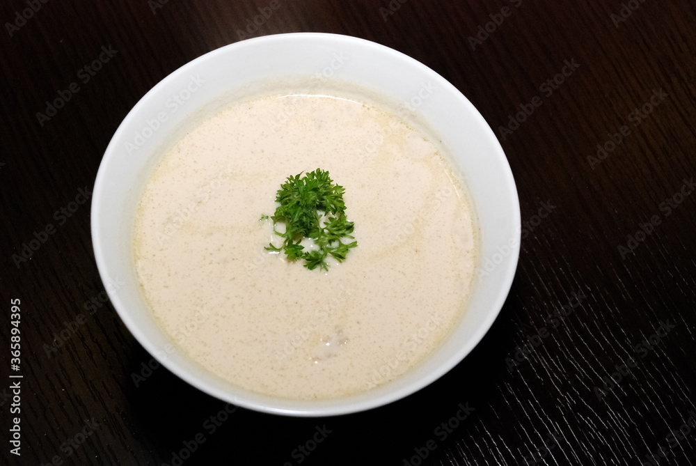 creamy soup in the white bowl and parsley in the middle creamy soup in the white bowl and parsley in the middle