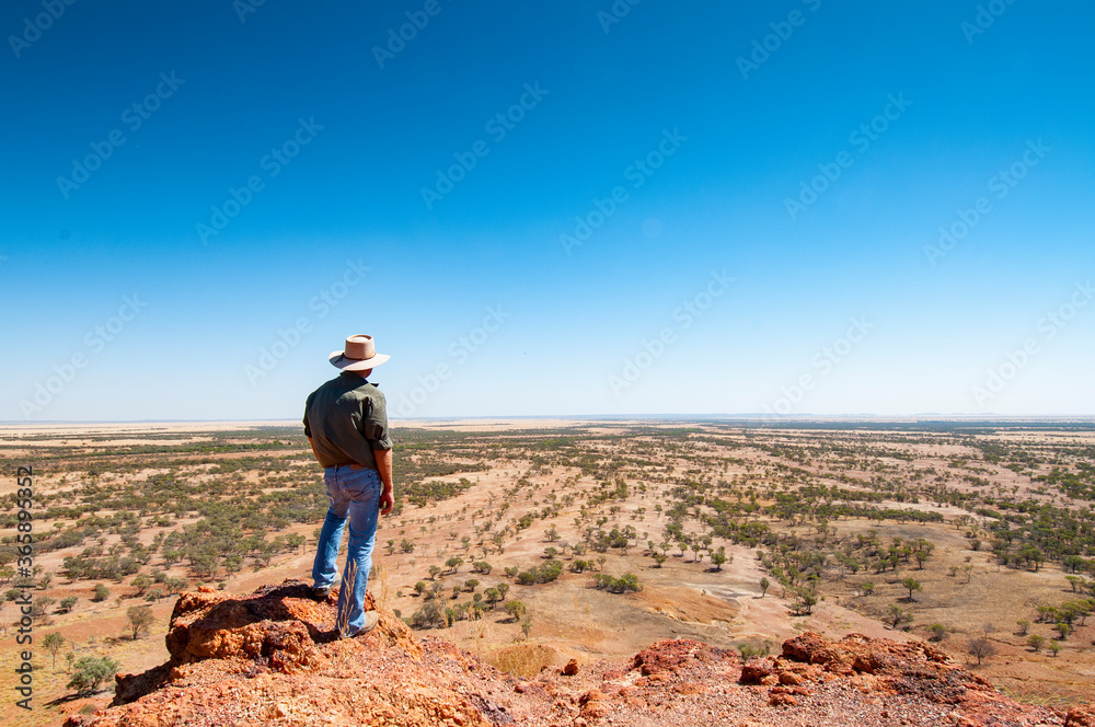 rancher looking out on Outback landscape, Queensland, Australia