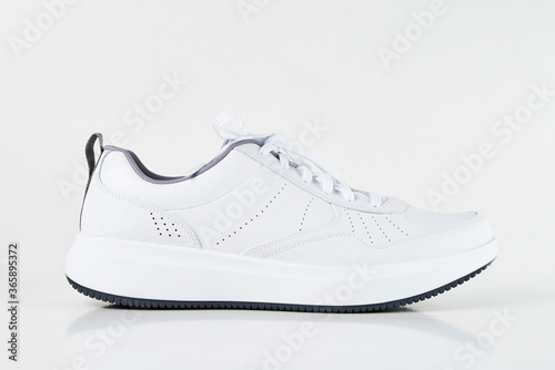 White male sneaker on white background isolated. Fashion stylish sport shoes, close up