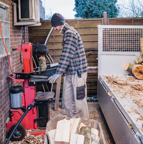 Fotografía Man cutting firewood with wood splitter