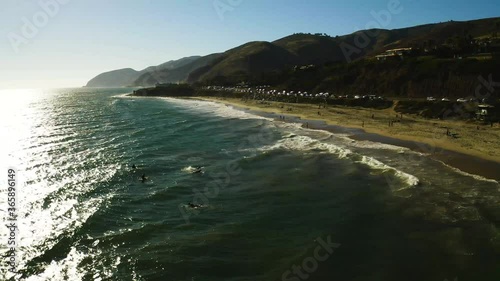 Surfers wait for ocean waves drone